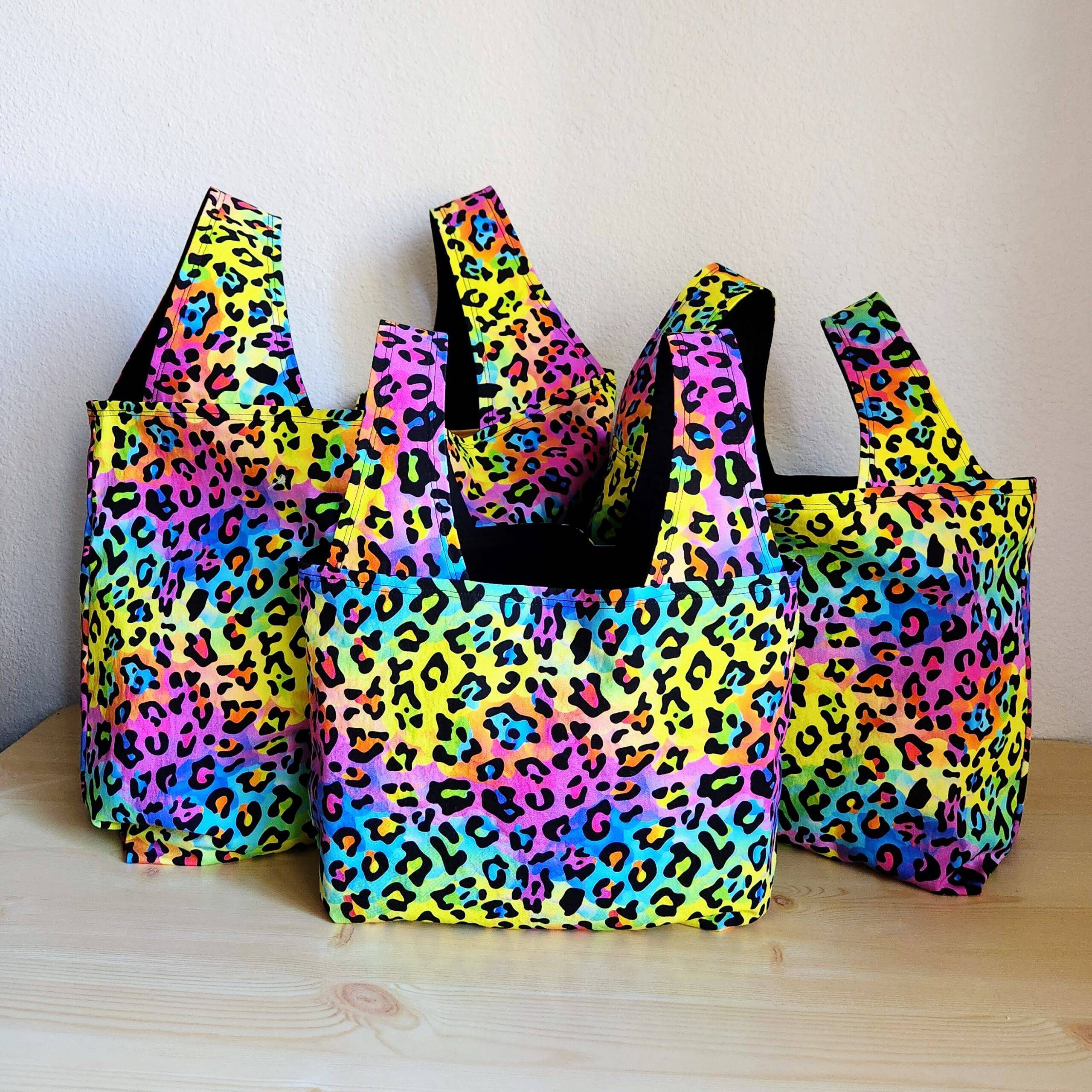 three rainbow leopard print reusable bags lined with black fabric