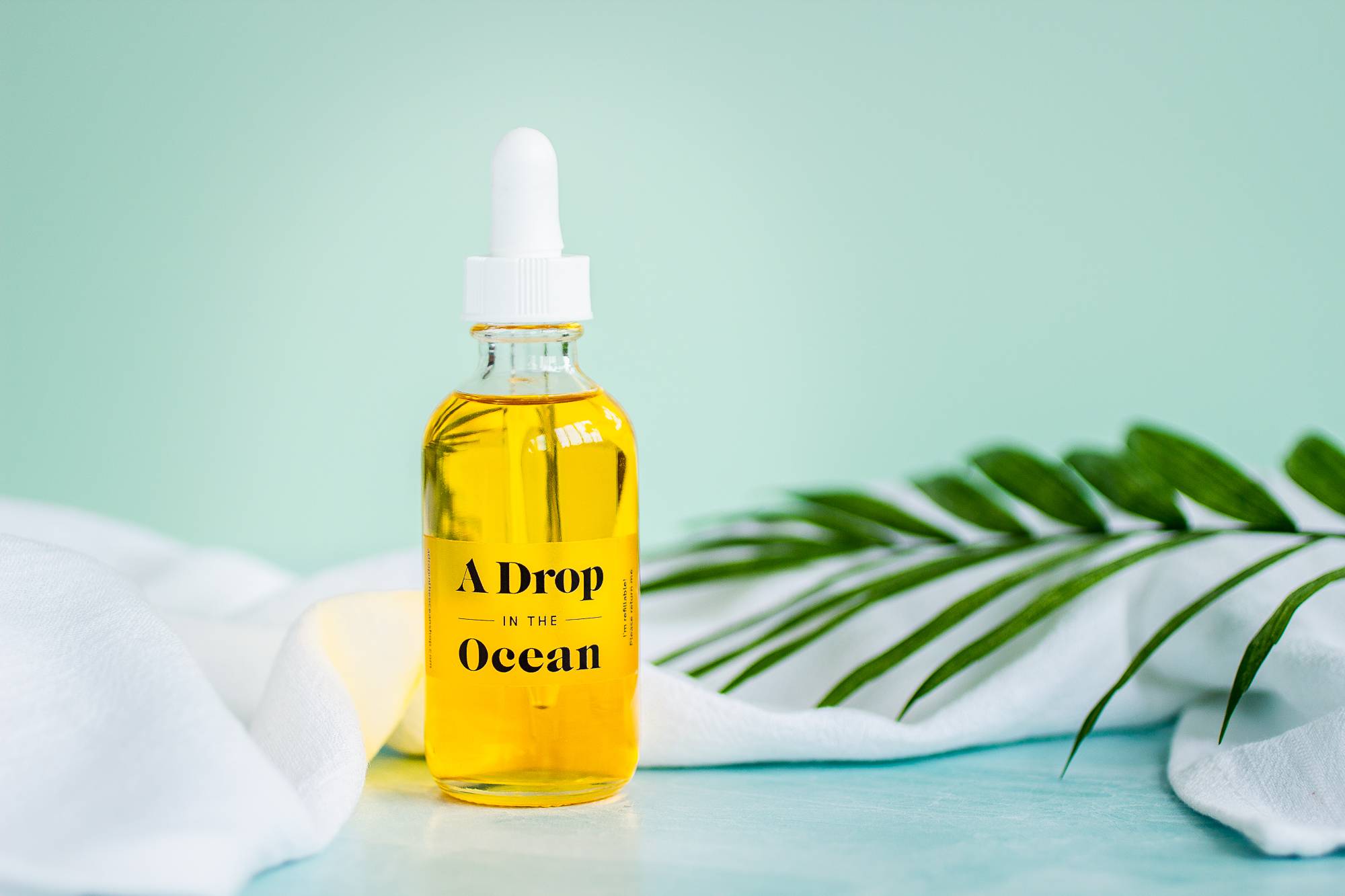 clear glass bottle with white dropper cap filled with refillable, revitalizing skin serum