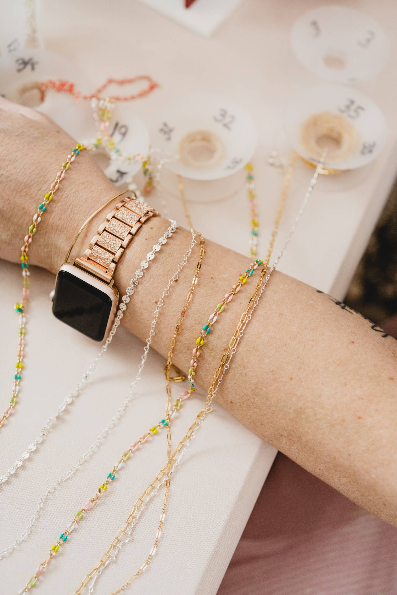 Permanent jewelry chains draped over an arm