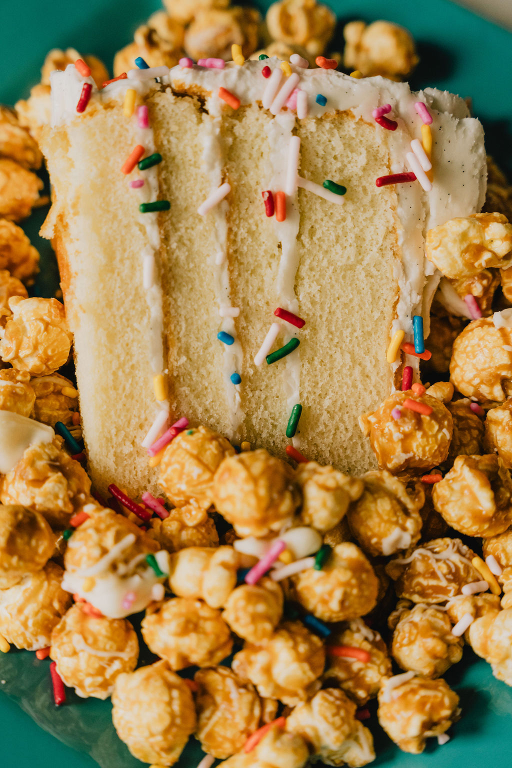 Confetti Cake Batter popcorn displayed with a piece of cake