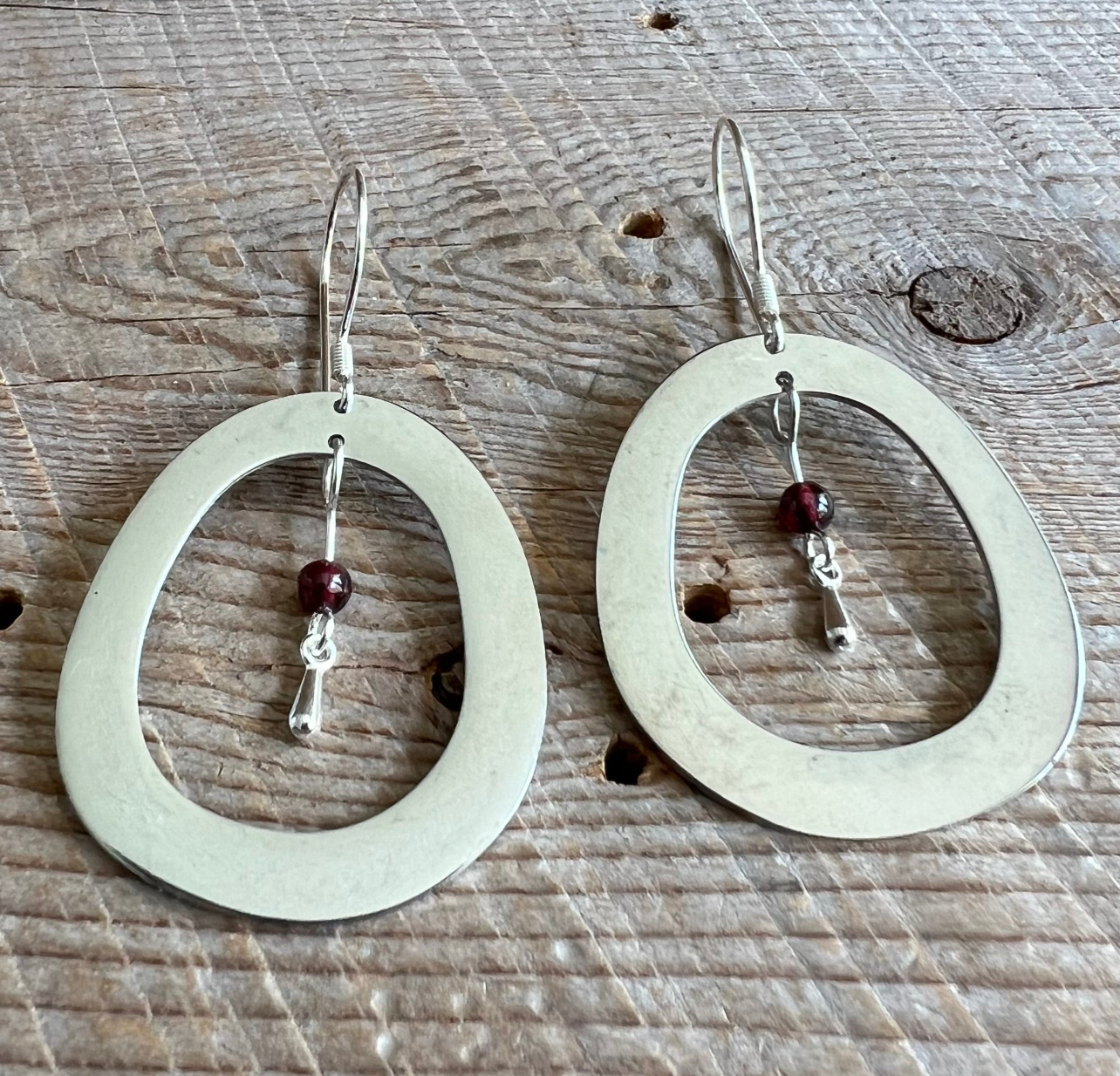 SariBlue earrings Laser cut stainless steel oval with garnets Sterling silver hooks Artisan made jewelry