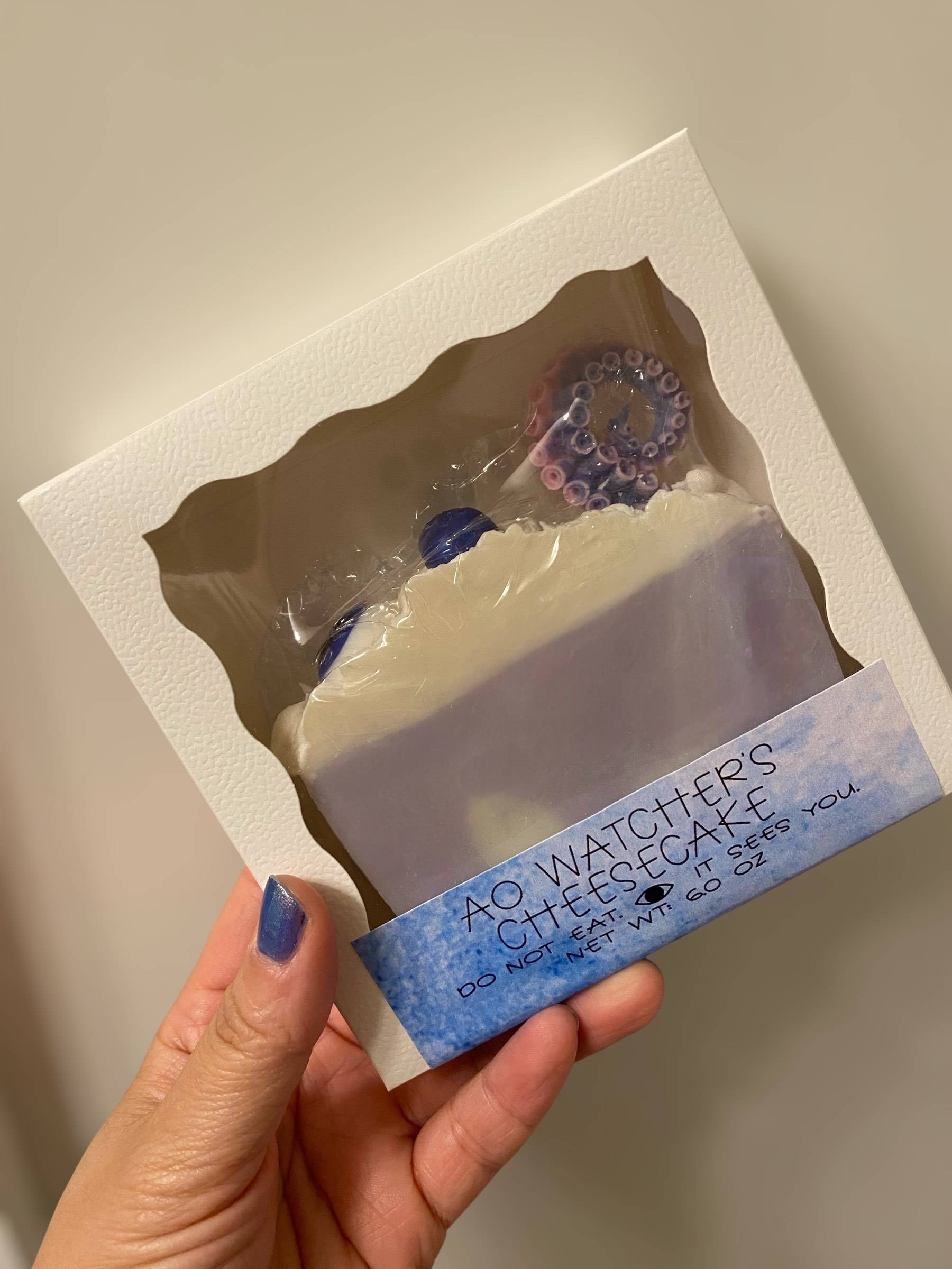 Soap in a white box labeled “Ao Watcher’s Cheesecake – Do Not Eat. It Sees You.”