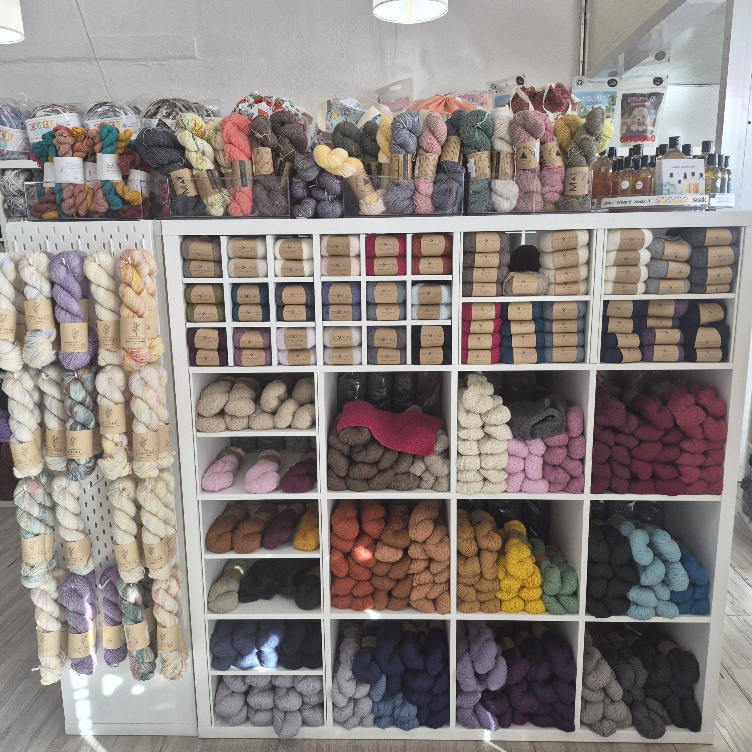 this photo shows a bookcase filled with colorful yarn.
