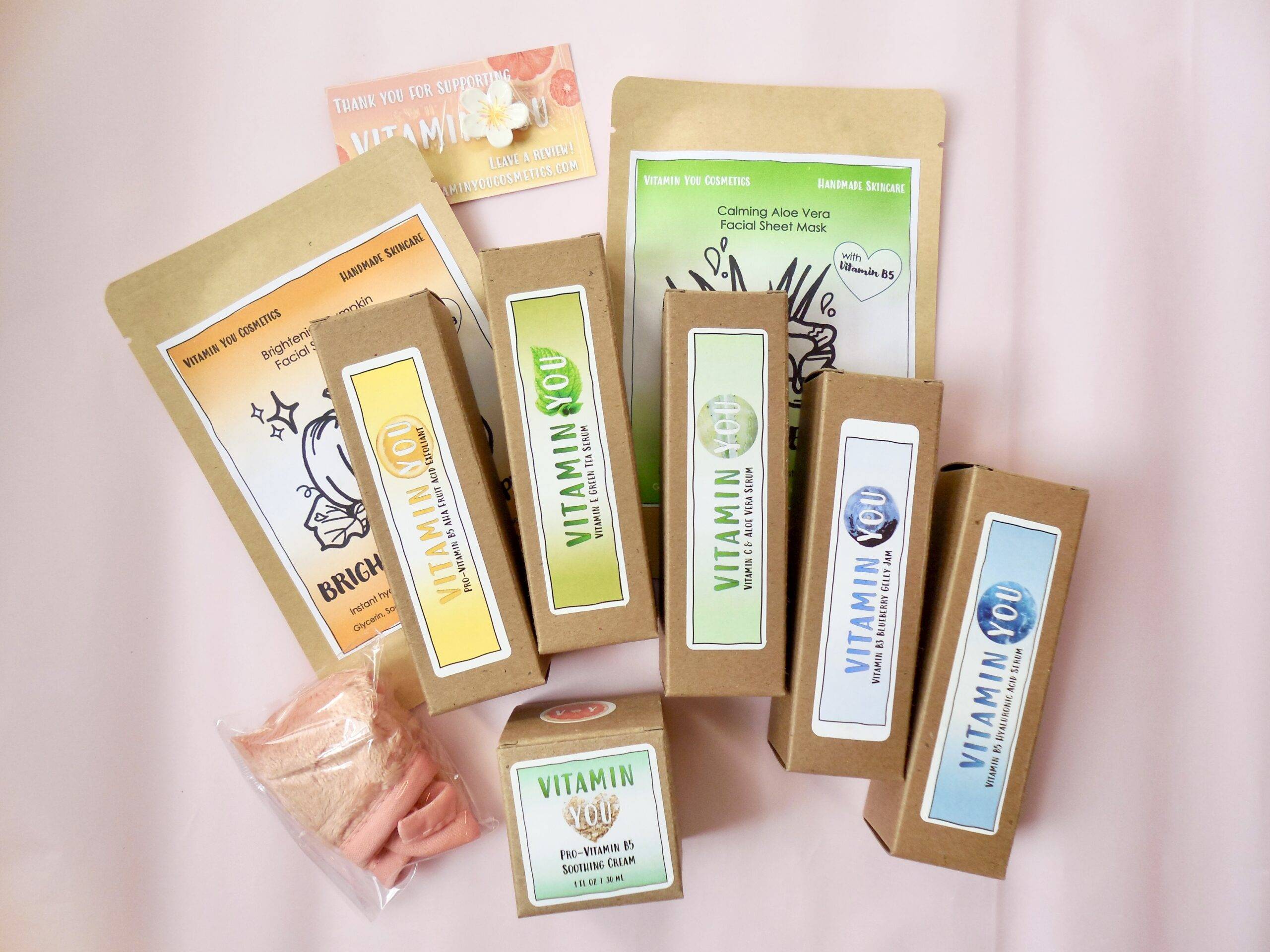 Array of skincare products displayed on a pink background.