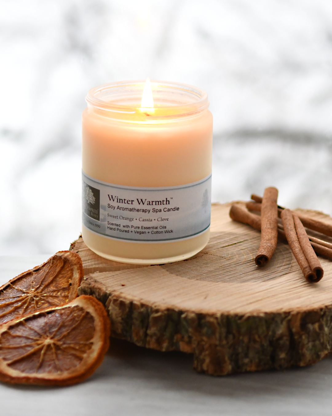 Winter Warmth aromatherapy candle in a snowy scene.