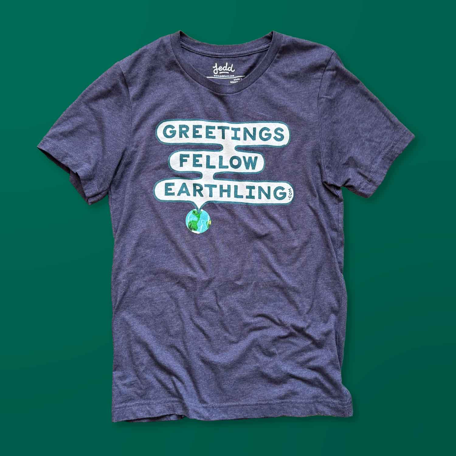 A blue t-shirt that says Greetings Fellow Earthling