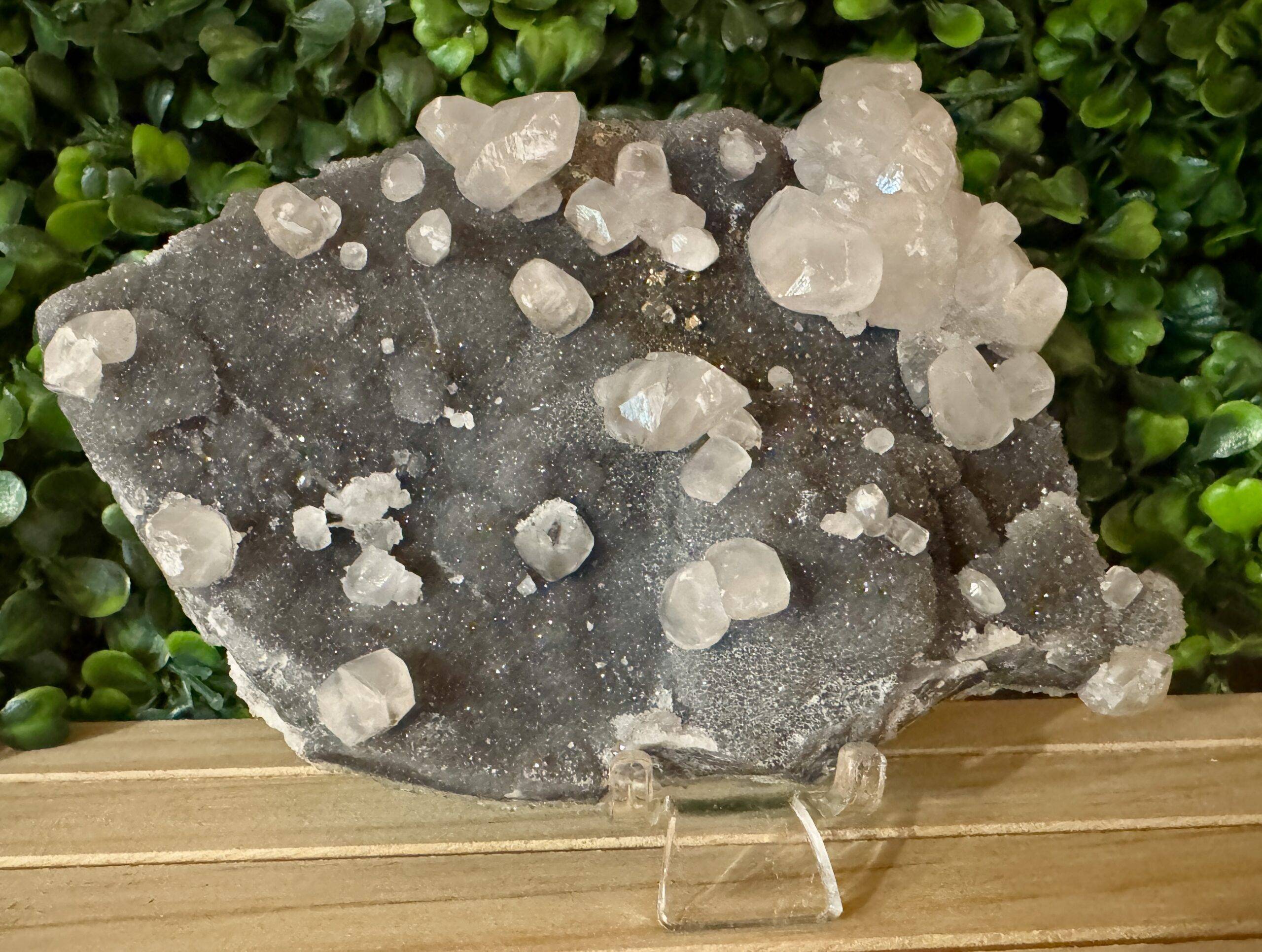 Black amethyst crystal with small white clear crystals growing on the surface.