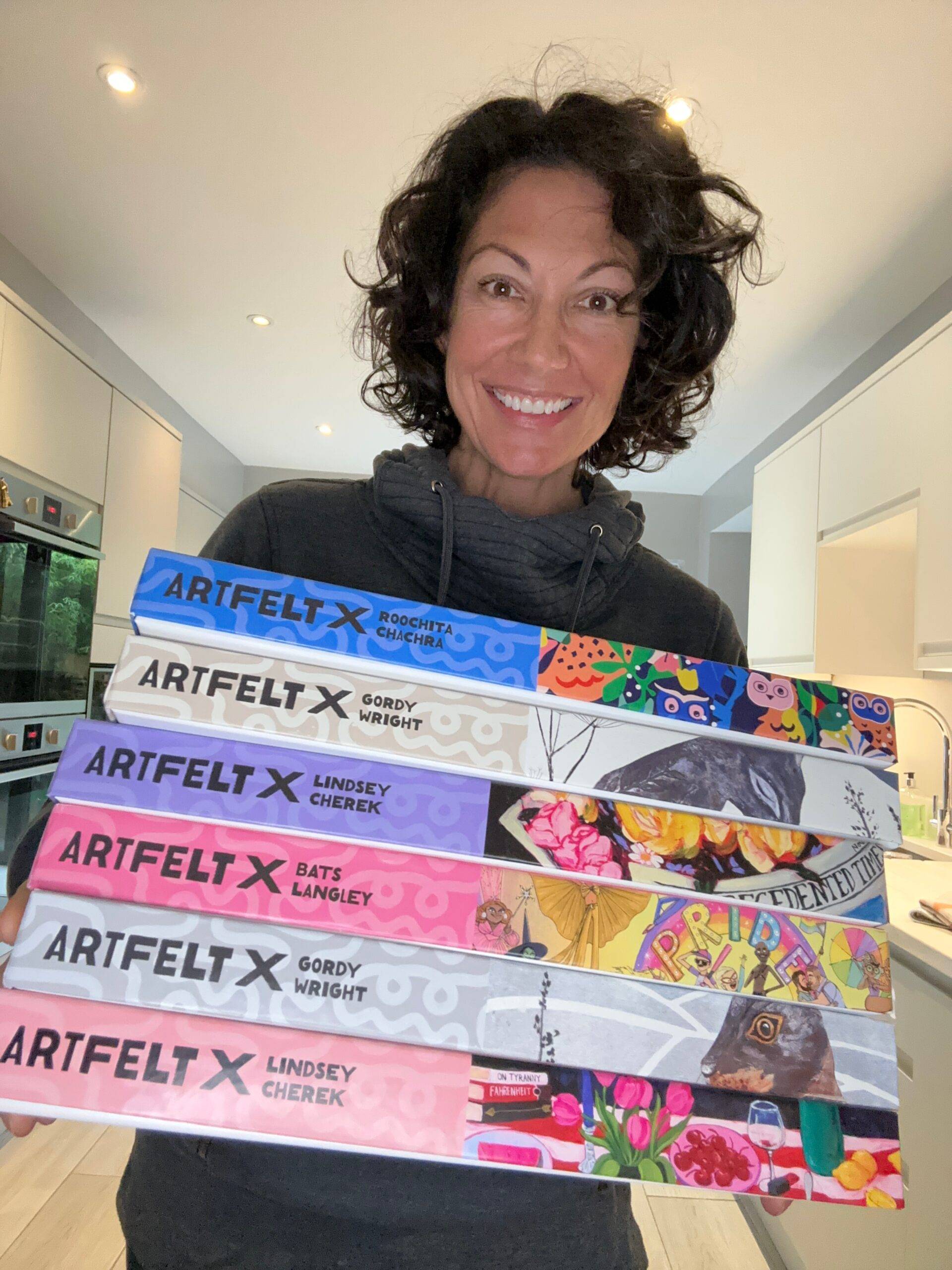 Woman holding a stack of Artfelt Puzzles jigsaw puzzles