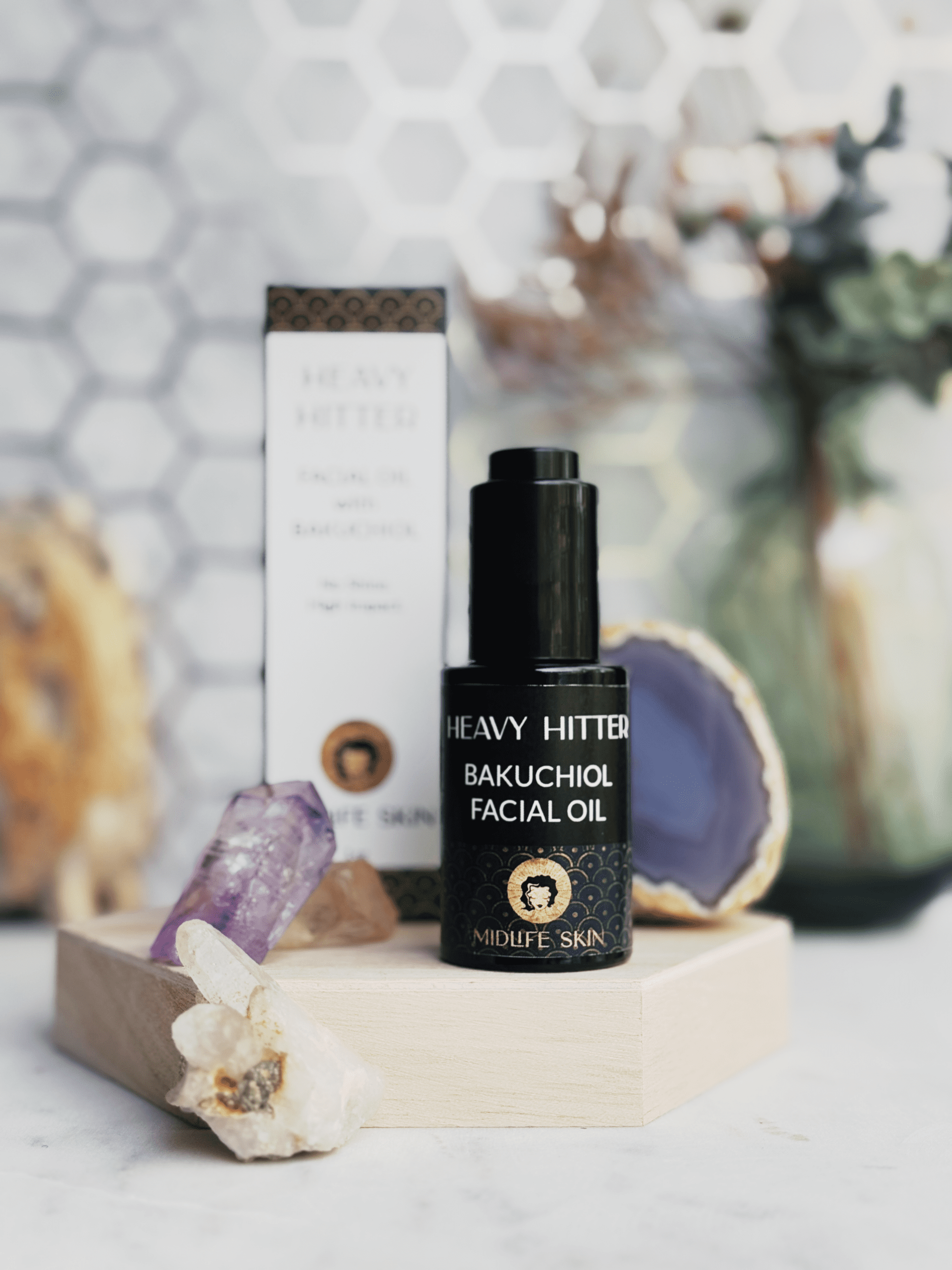 Brightly lit photo of a black dropper bottle with a label that says Heavy Hitter, Bakuchiol facial oil.