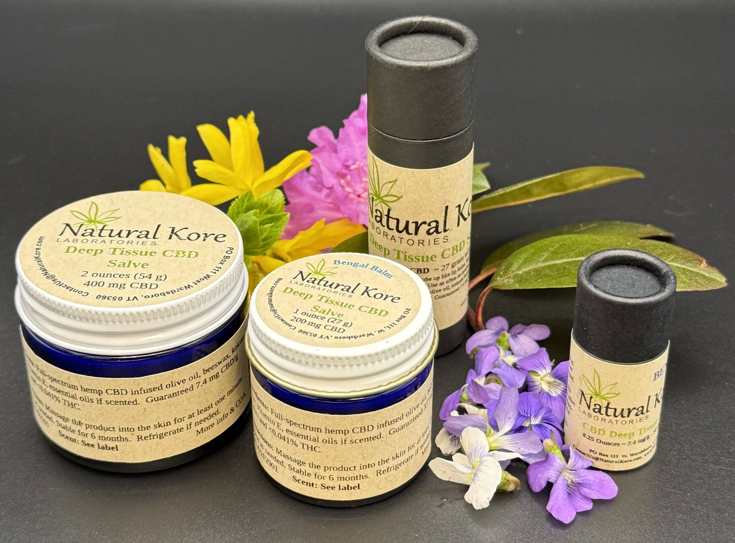Natural Kore CBD Deep Tissue Salve in various containers including the blue glass jars and kraft-board tubes