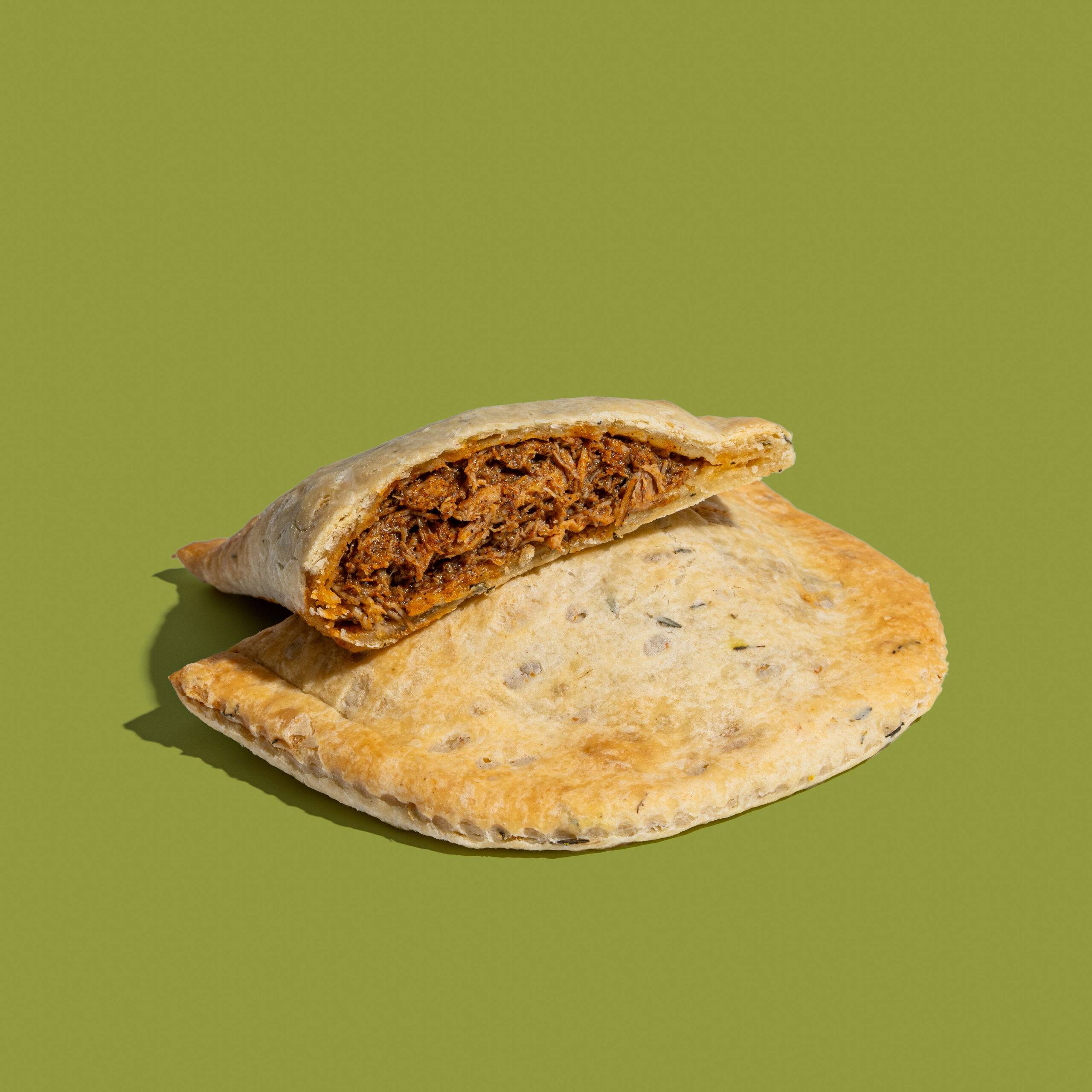 BBQ Jerk Chicken patty with thyme crust sliced in half.