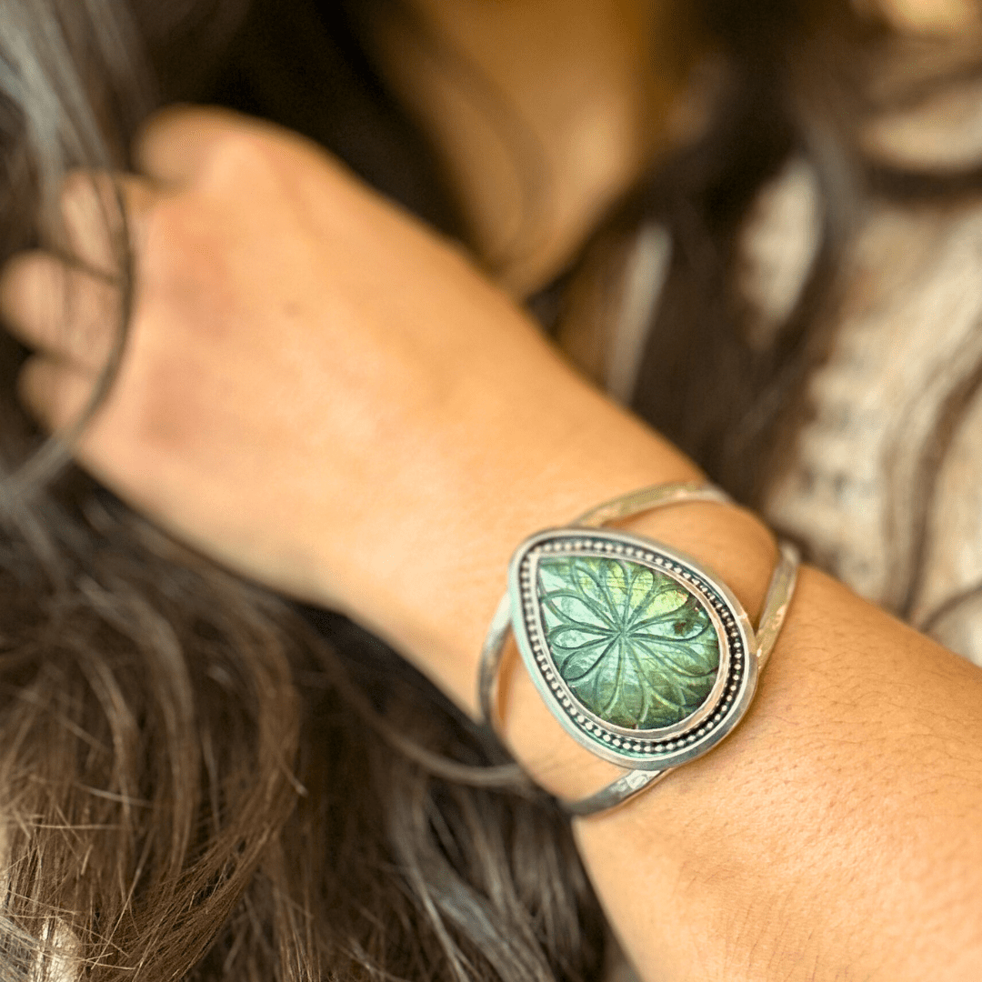Image of sterling silver cuff bracelet with a carved labradorite stone and a border of silver wire with different patterns